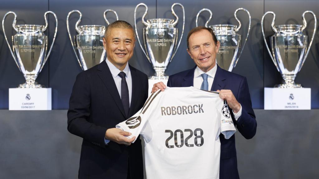 Quan Gang, presidente de Roborock (izqu.) firma el acuerdo con Emilio Butragueño, director de Relaciones Institucionales del Real Madrid (der.).