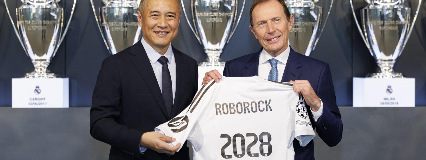 Quan Gang, presidente de Roborock (izqu.) firma el acuerdo con Emilio Butragueño, director de Relaciones Institucionales del Real Madrid (der.).