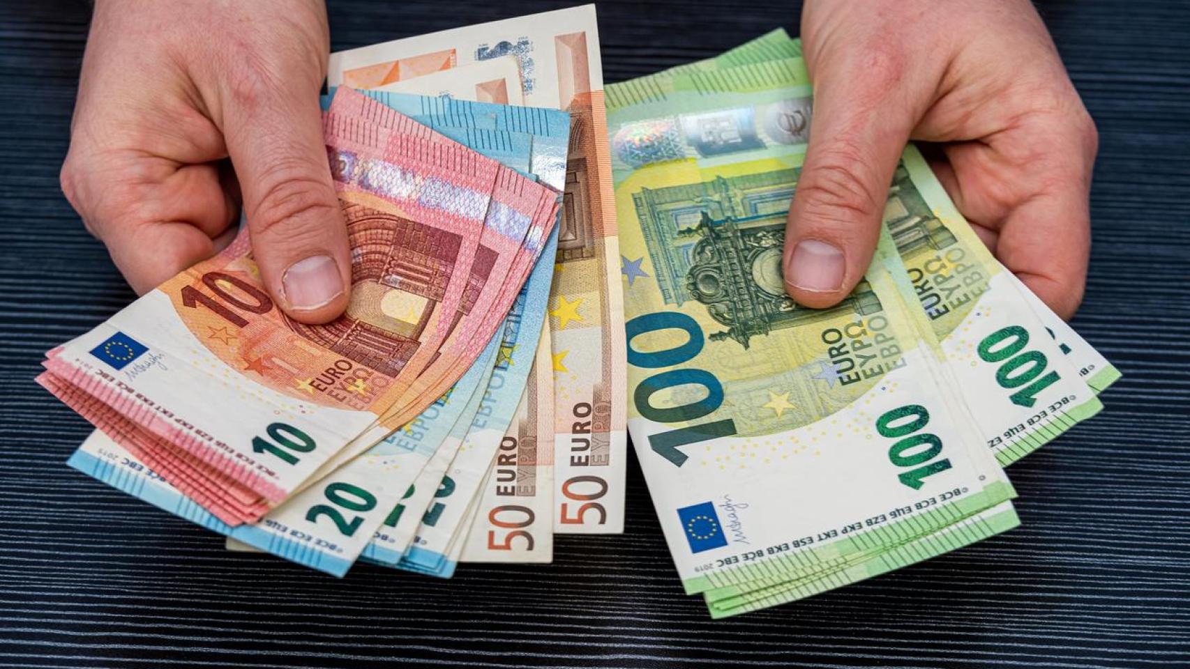 Una persona sosteniendo varios billetes.