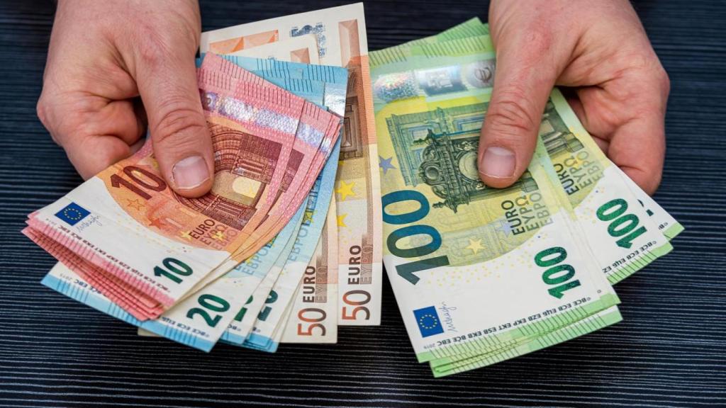 Una persona sosteniendo varios billetes.