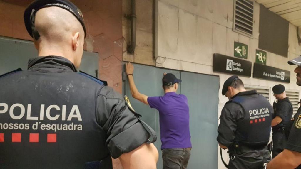 Agentes de los Mossos d'Esquadra registran e identifican a un sospechoso.
