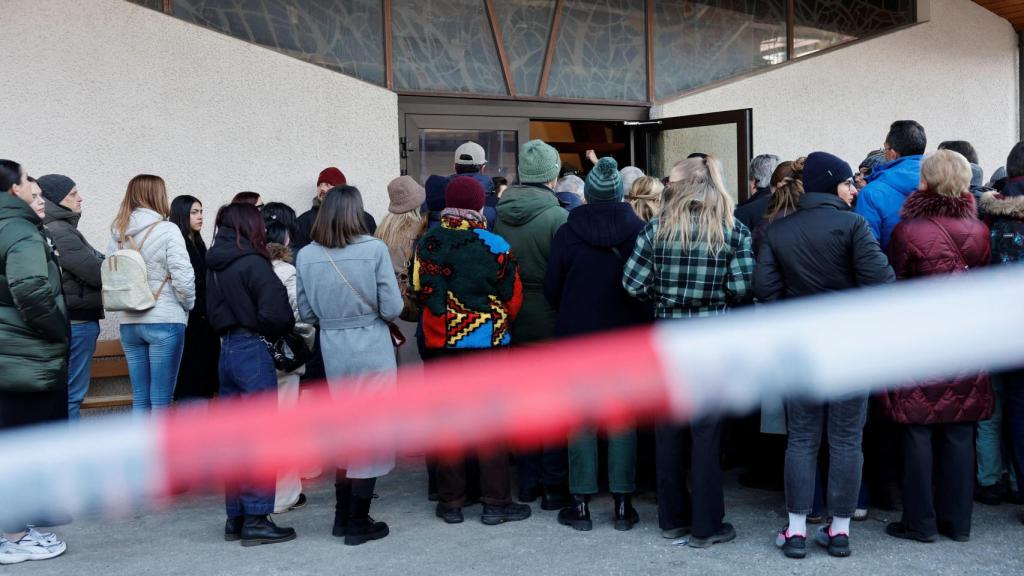 Personas se encuentran afuera de la capilla de San Cristóbal durante una misa en honor a las víctimas del incendio