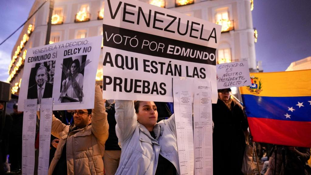Venezolanos exhiben el retrato de Edmundo González y una copia de las actas de las elecciones, anoche en la Puerta del Sol de Madrid.