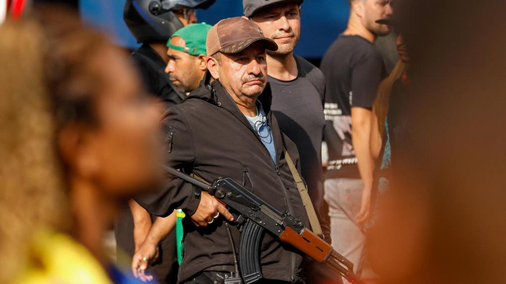 A paramilitary, armed and with a radio, on the streets of Caracas.