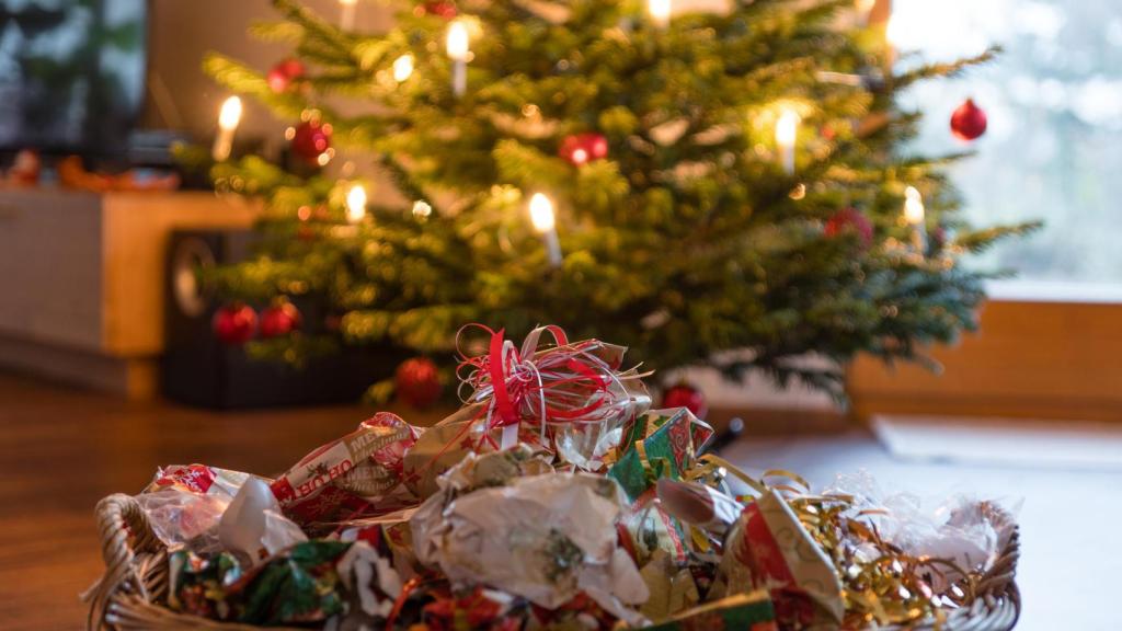 Imagen de archivo del papel de regalo usado bajo el árbol de Navidad.