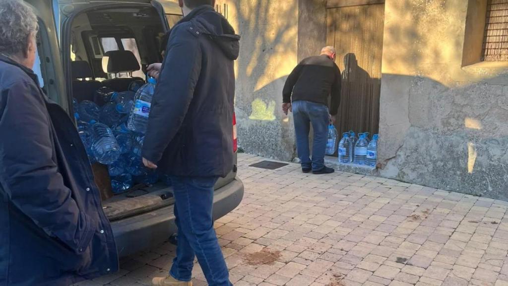 Responsables del Ayuntamiento de Atienza (Guadalajara) repartiendo agua embotellada.