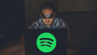 Montaje de un hacker con un ordenador con el logotipo de Spotify