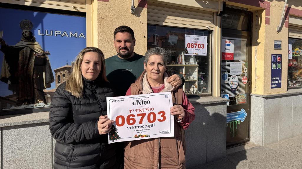 Lourdes García y sus hijos Pablo y Marta Morán, propietarios del autoservicio Lupama, en Fontiveros (Ávila), que ha repartido un décimo del primer premio de la Lotería del Niño, n.° 06703.