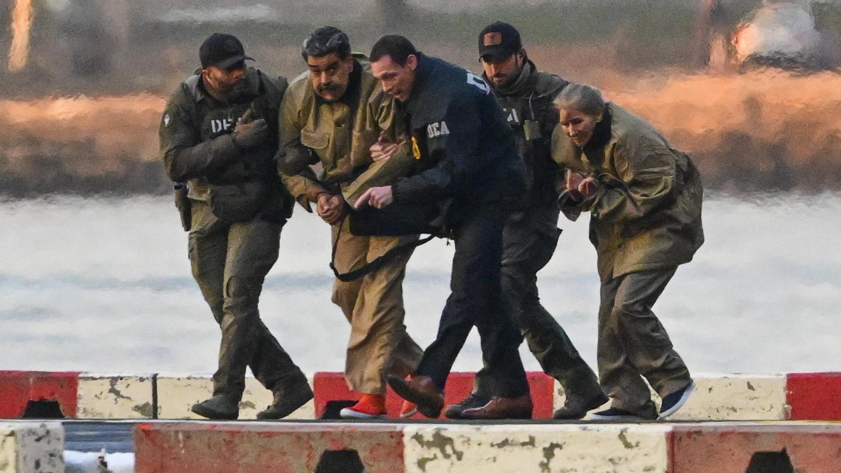 El presidente de Venezuela, Nicolás Maduro (2-i) y su esposa, Cilia Flores (d), llegan al helipuerto de Wall Street este lunes, para ser traslados al tribunal federal en Nueva York.
