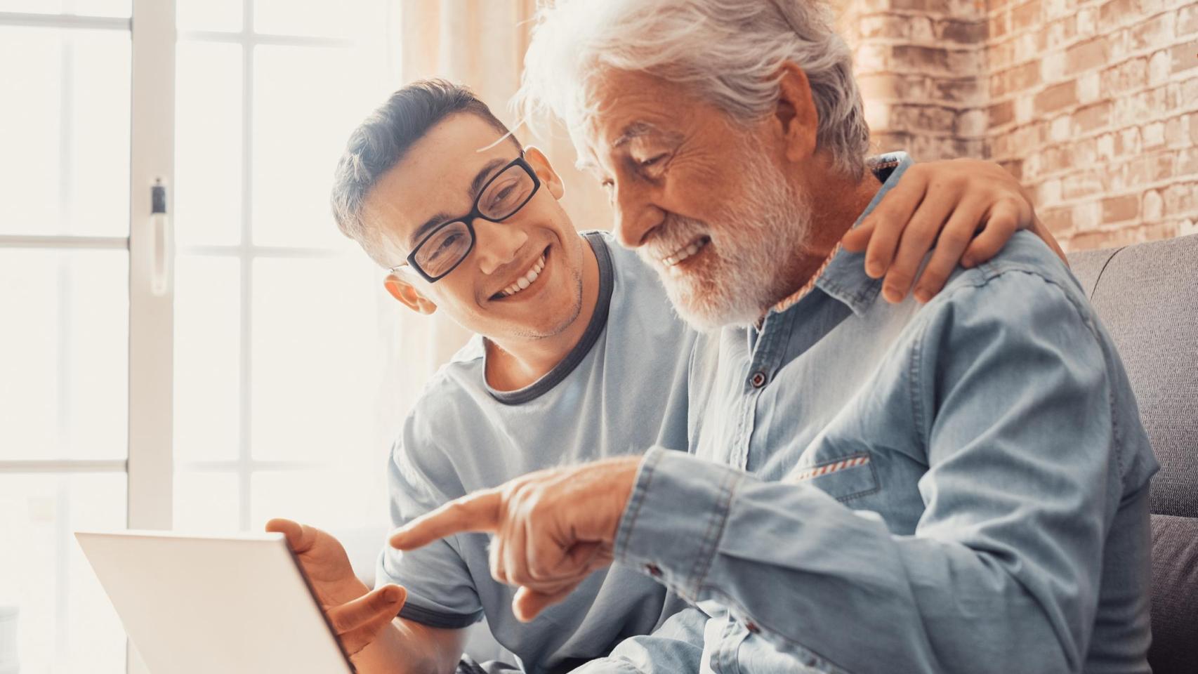 Un hombre mayor y un joven sentados juntos en un sofá.