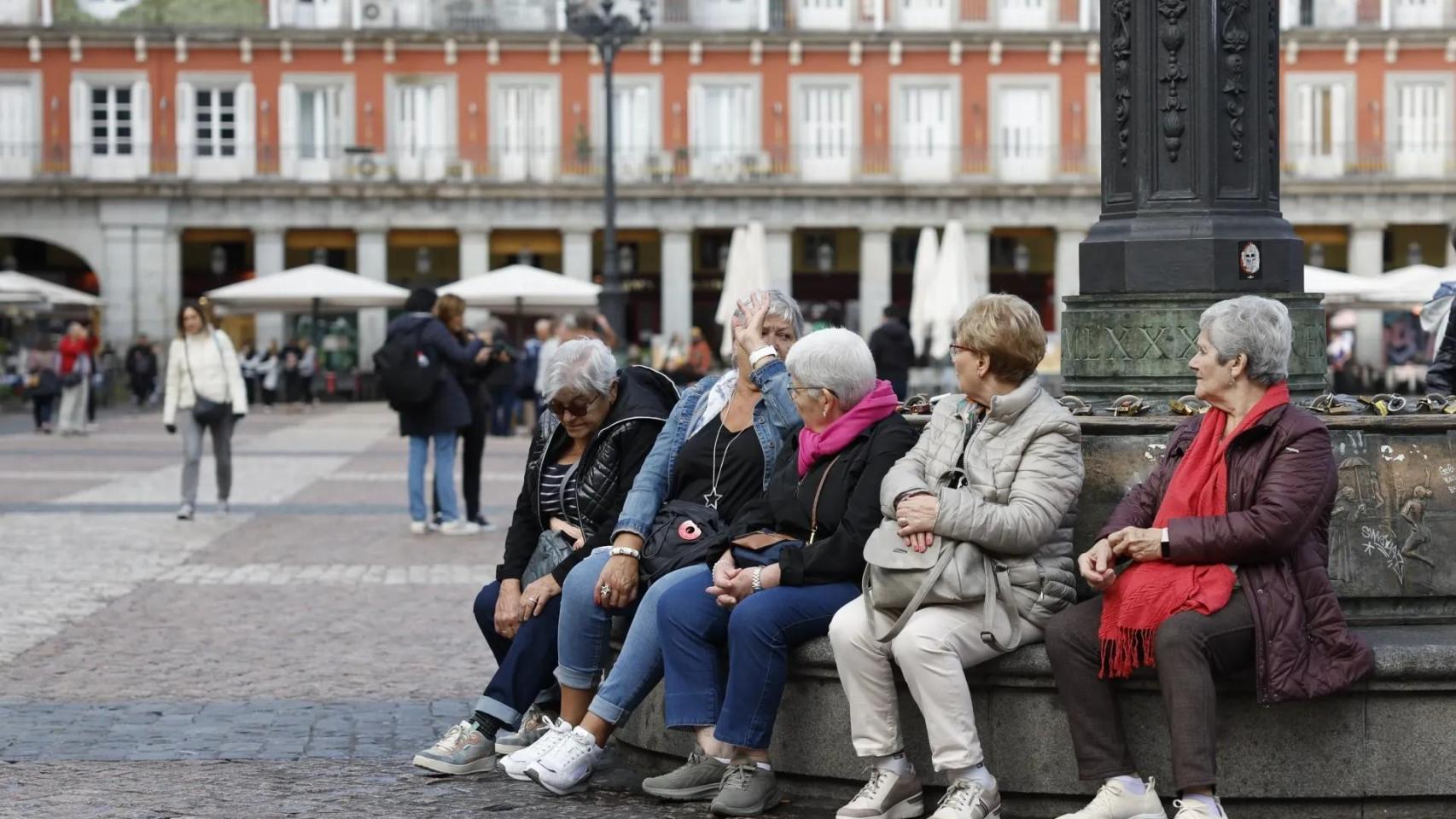 Jubiladas sentadas en una plaza.