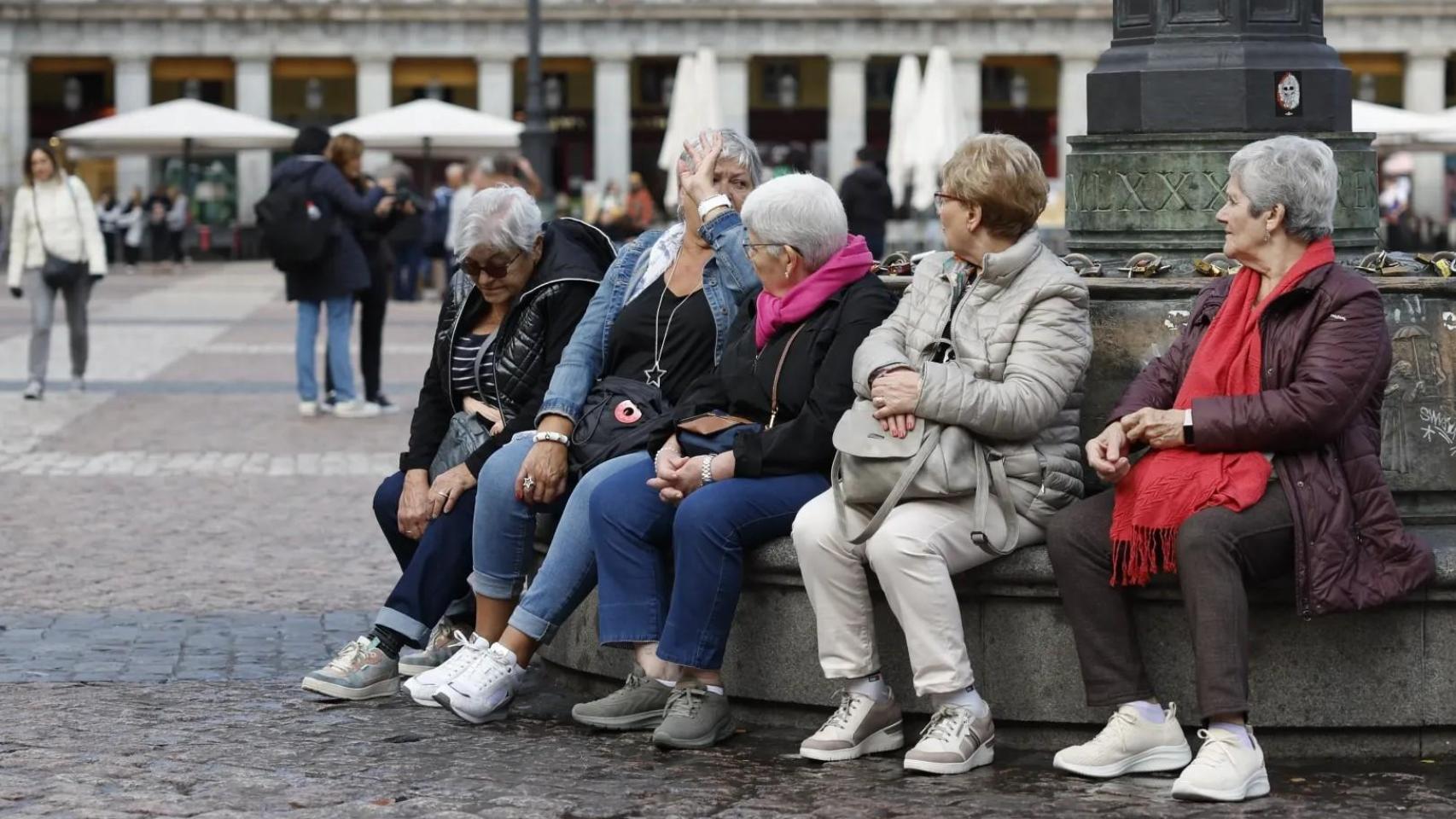 Jubiladas sentadas en una plaza.