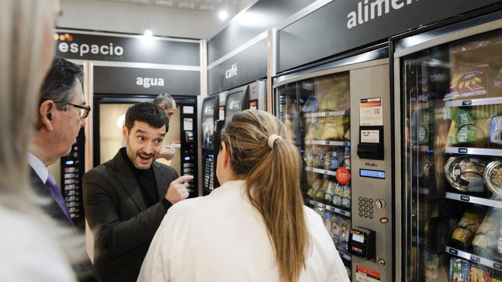El ministro de Derechos Sociales, Consumo y Agenda 2030, Pablo Bustinduy, junto a una maquina expendedora, durante una visita al Hospital Nacional de Parapléjicos.