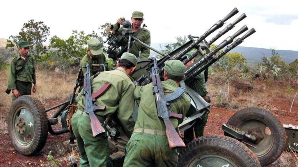Soldados cubanos maniobran una ametralladora antiaérea, popularmente conocida como cuatro bocas.