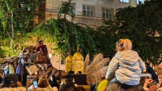 Una niña a hombros de su padre viendo la cabalgata de los Reyes Mayos en Alicante.