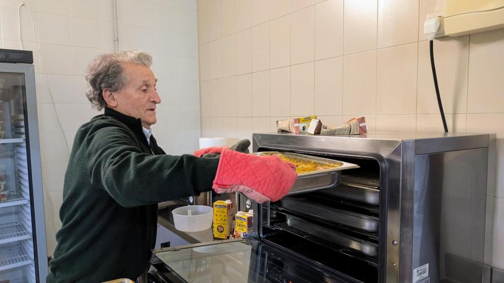 Uno de los voluntarios calienta el plato del día, cocinado por Alicante Gastronómica.
