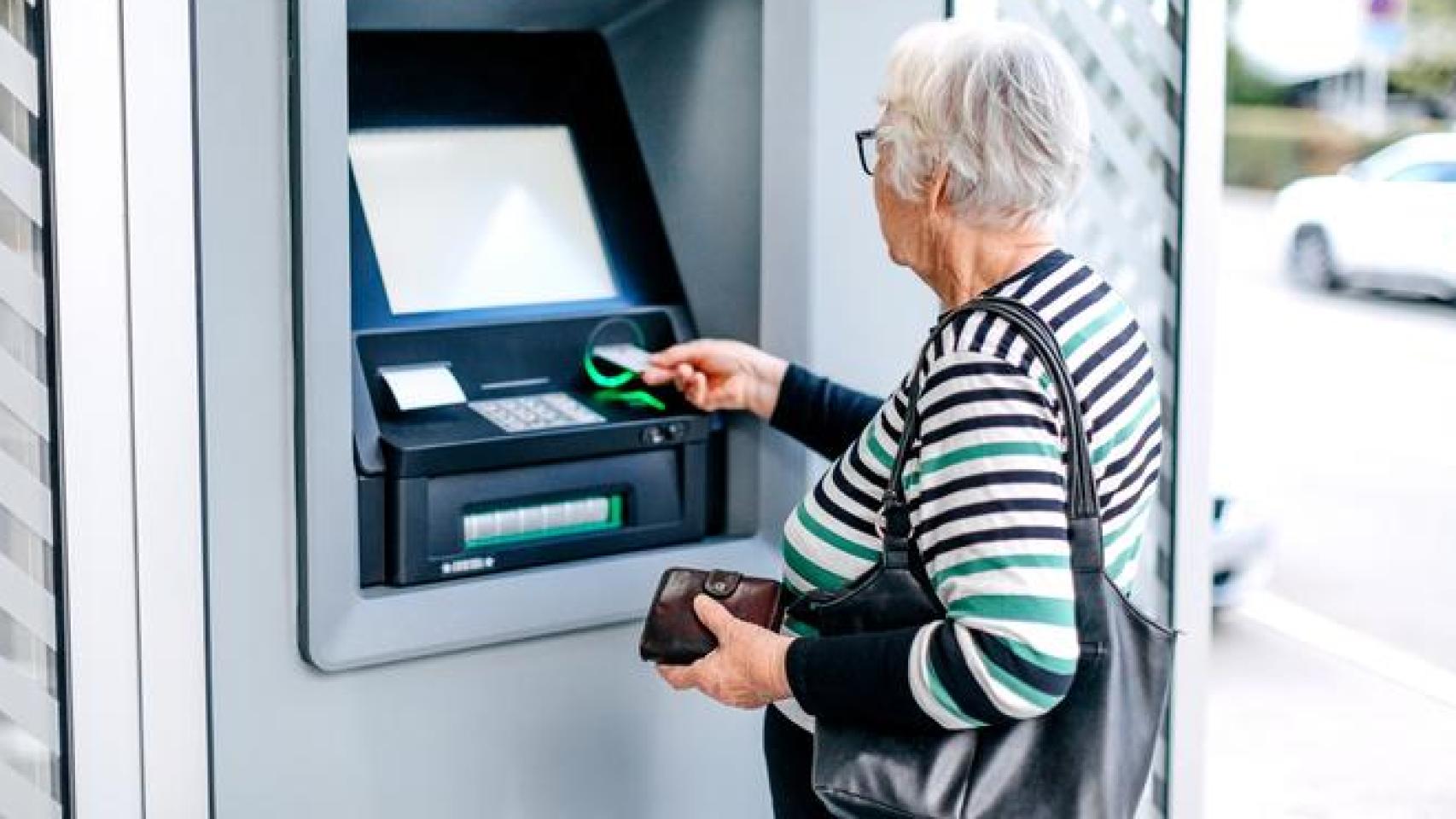 Señora sacando dinero de un cajero automático.