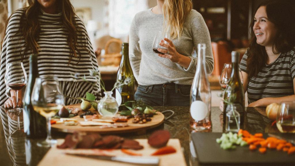 Imagen de archivo de un grupo de amigas en torno a una mesa con comida copiosa.