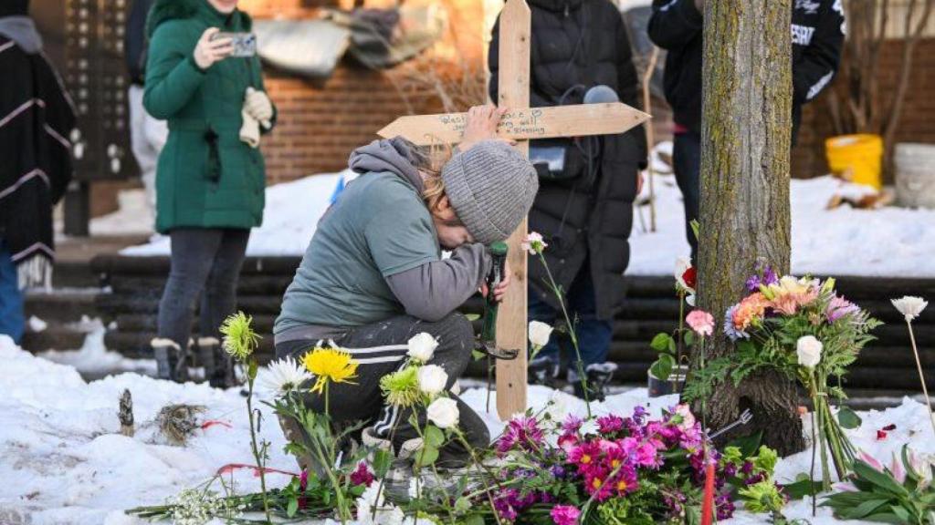 Una mujer ora en un monumento en el lugar en el que Renee Nicole Good fue asesinada a tiros en Minneapolis.