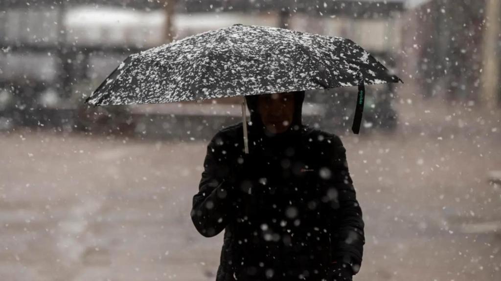 Un hombre se protege de la nieve en el centro de Vitoria