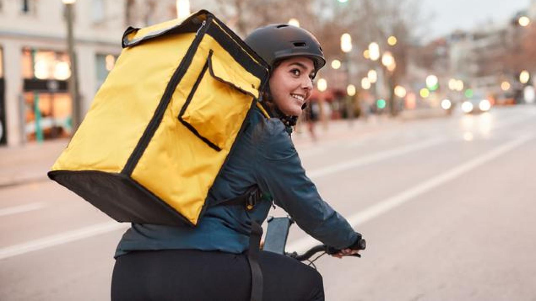 Una repartidora en bicicleta.