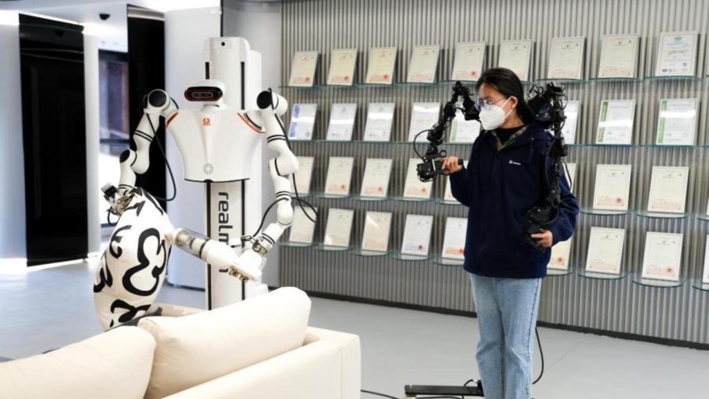 Una operadora con un exoesqueleto entrenando a un robot en el Humanoid Robotics Innovation Center de Pekín.