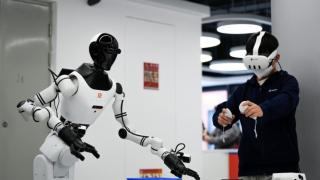 Un operador humano enseñando tareas a un robot en un centro de entrenamiento de Pekín.