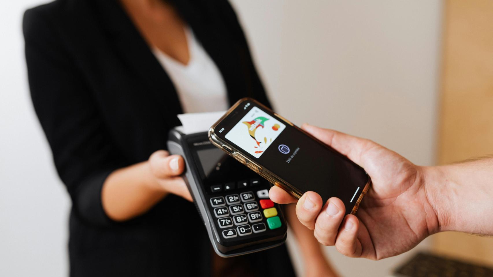 Una persona paga una compra en un comercio con tarjeta de crédito.