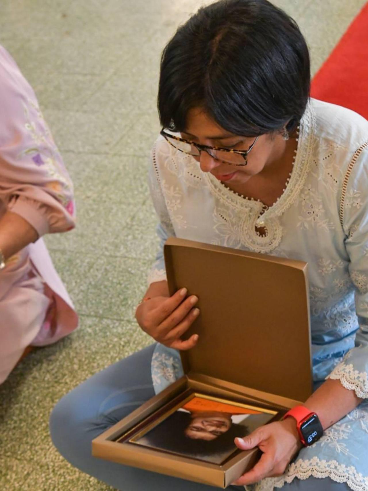 Delcy Rodríguez sujeta en sus manos el retrato de Sai Baba en la ciudad de Puttaparthi durante su última visita, en 2023.