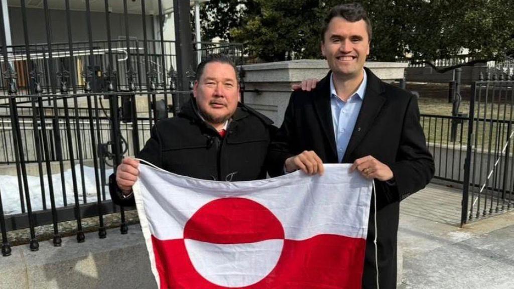 Jörgen Boassen junto a Charlie Kirk sosteniendo la bandera de Groenlandia.