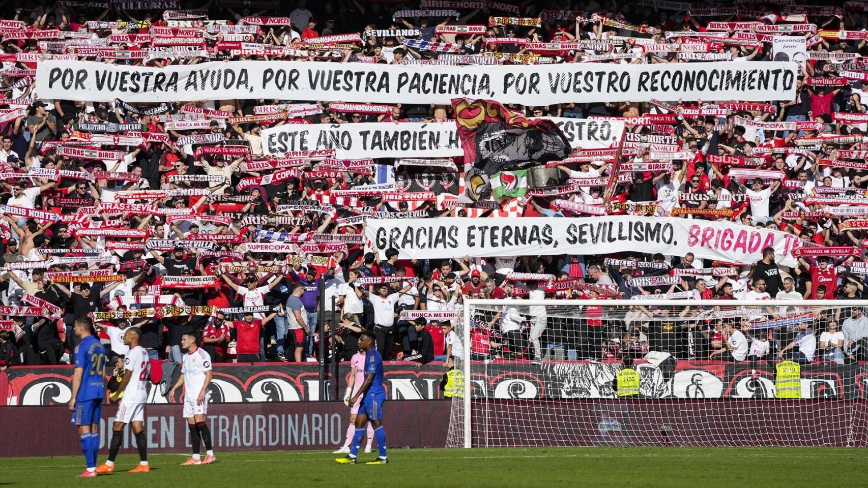 Los aficionados del Sevilla despliegan una pancarta durante el partido ante el Real Oviedo.
