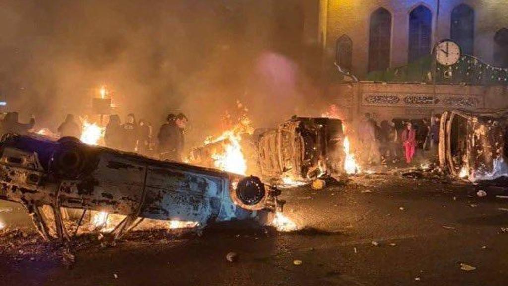 Manifestantes queman vehículos en la Kaj Square de Teherán, Irán.