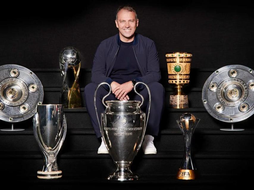 Hansi Flick posa com todos os títulos que conquistou pelo Bayern de Munique.