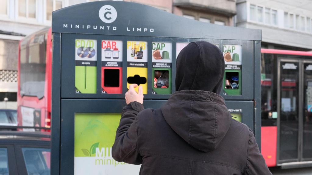 Una persona utiliza un mini punto limpio en A Coruña.