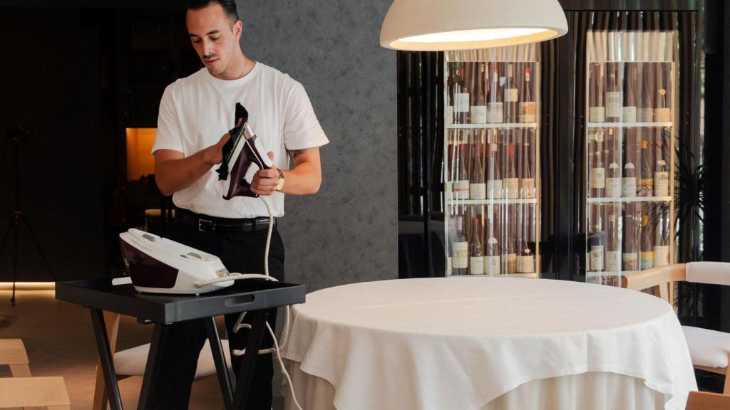 El jefe de sala, planchando los manteles del restaurante.