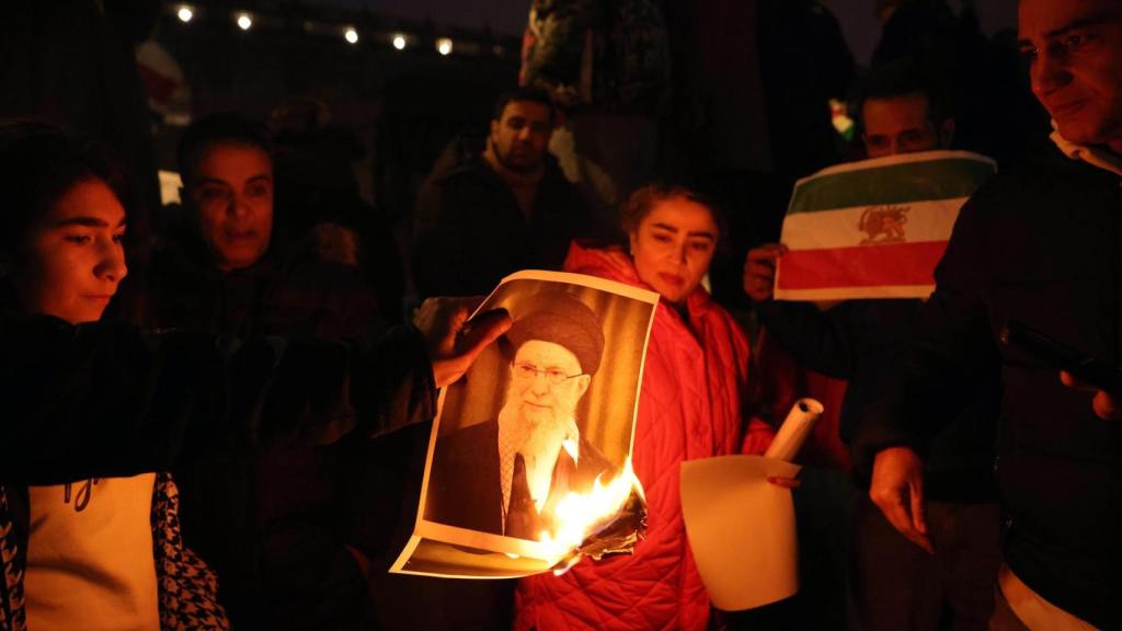 Fotografía de una chica quemando una imagen del líder supremo.