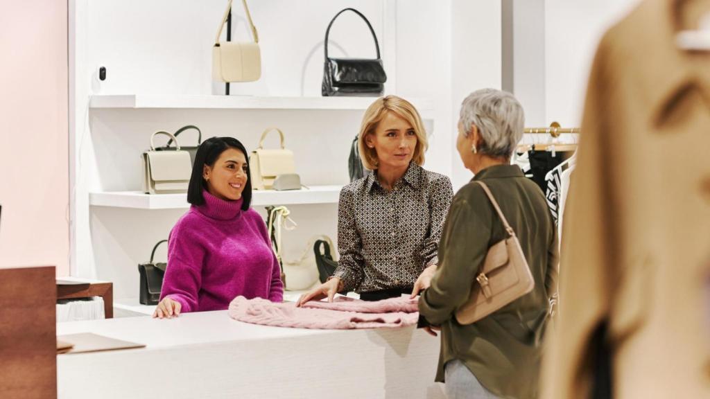 Dependientas y clienta en una tienda de ropa