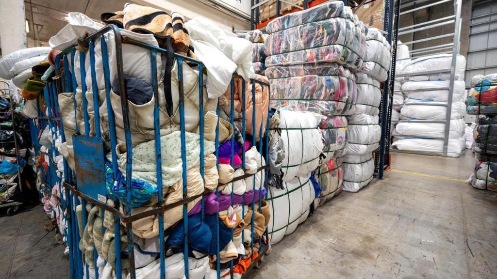Ropa usada recogida en una planta industrial.