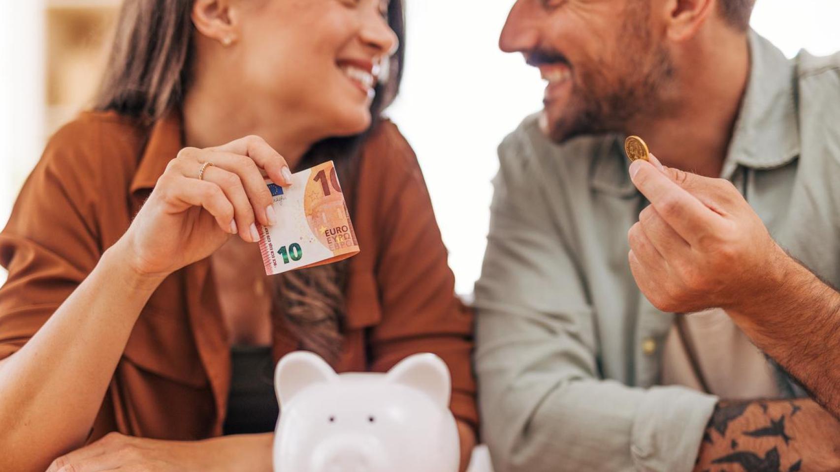 Una pareja joven ahorrando dinero.