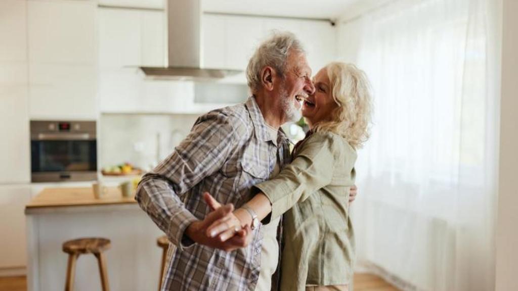 Pareja bailando en la cocina.