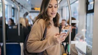 Mujer en el transporte público con el móvil.