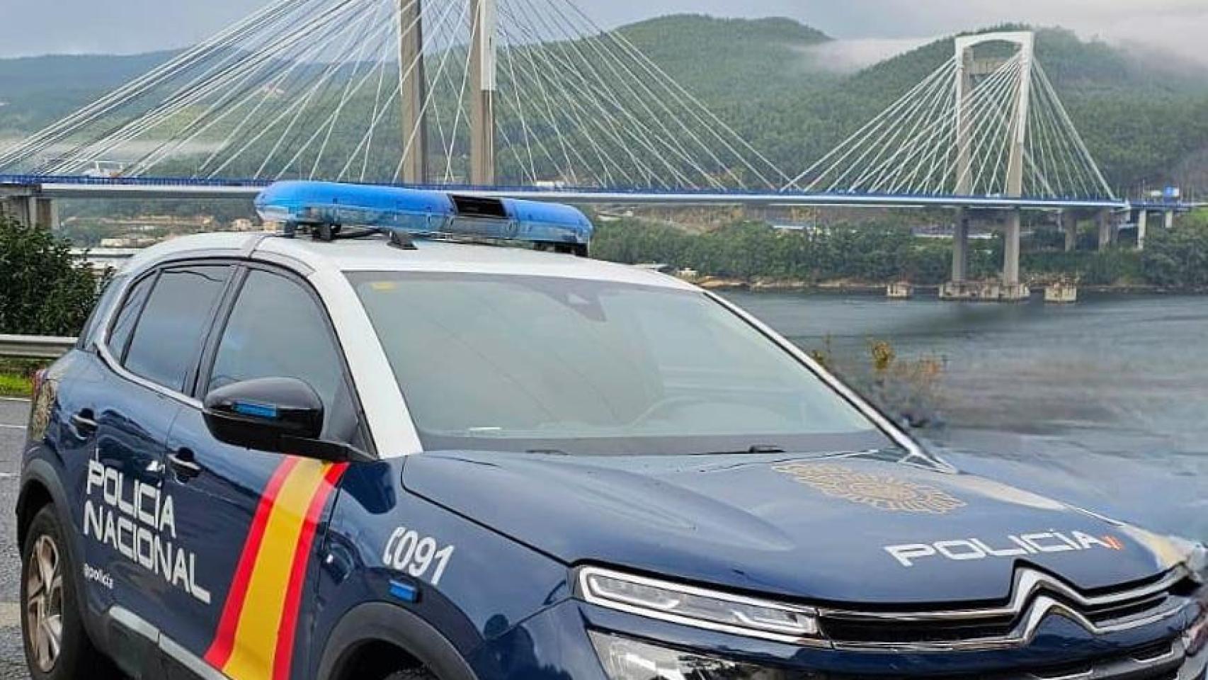 Un coche de la Policía Nacional con el Puente de Rande de fondo.