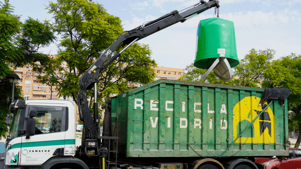 Un camión de reciclaje recogiendo el contenedor de vidrio.