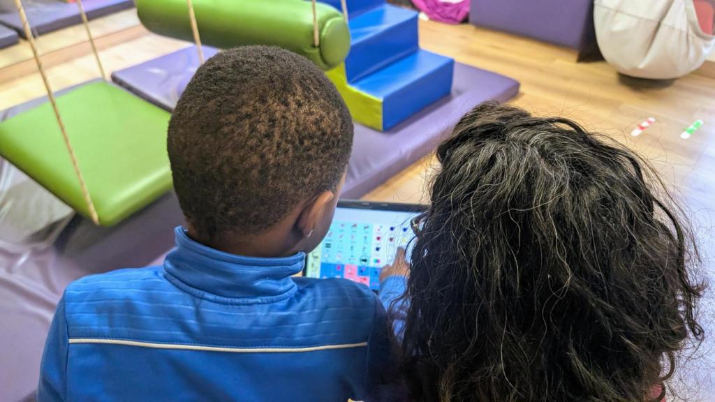 Laura, junto a un niño en una sesión de terapia ocupacional.