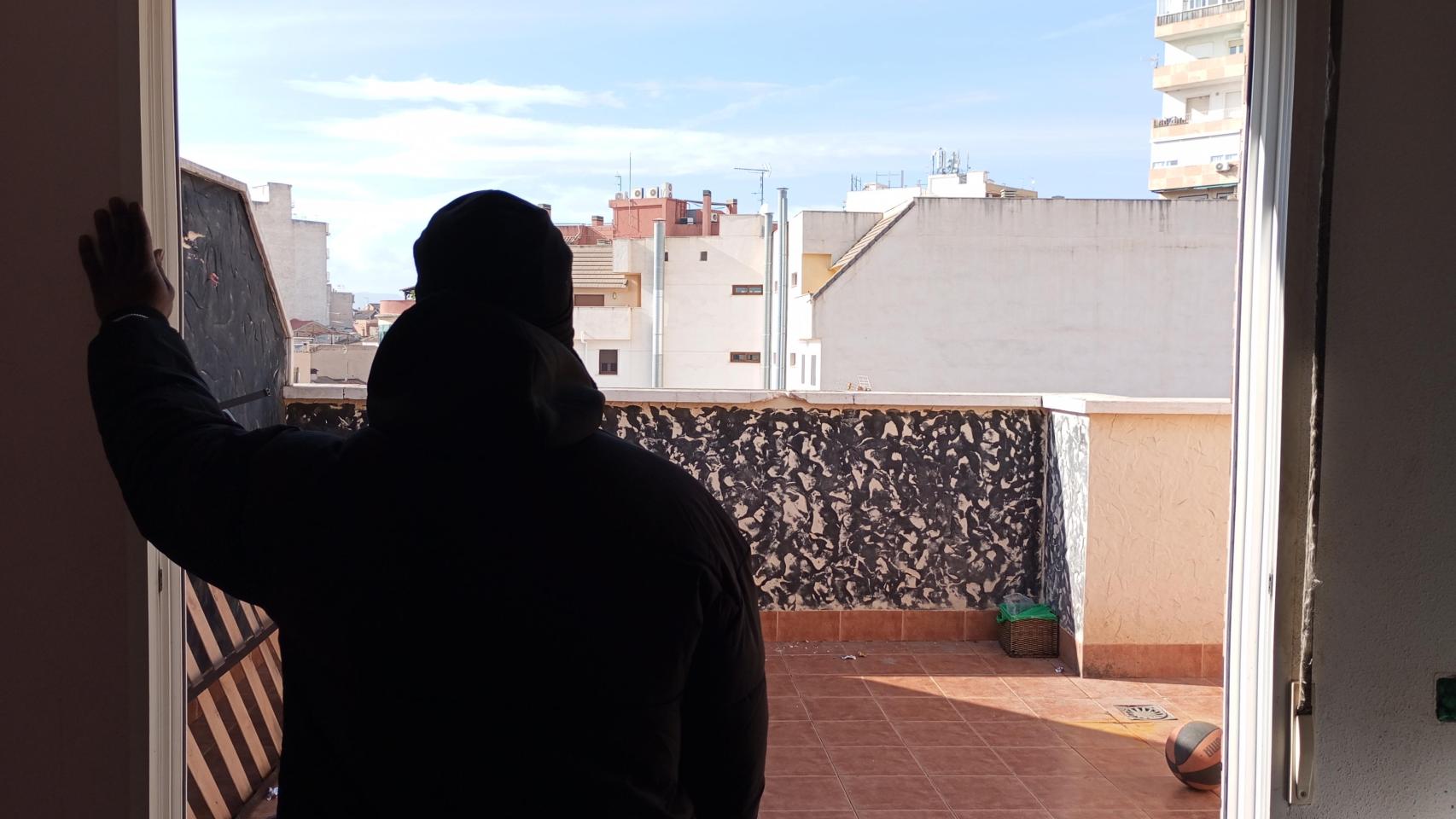 El guineano que ha declarado ante la Guardia Civil, este miércoles, asomado a la terraza del ático desde la que cayó al vacío su amigo 'Momo'.
