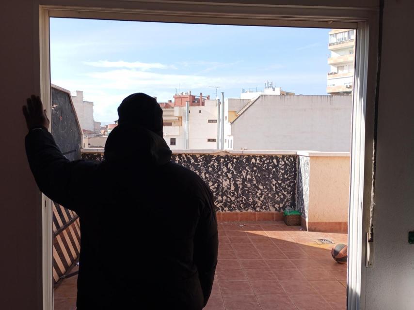 El guineano que ha declarado ante la Guardia Civil, este miércoles, asomado a la terraza del ático desde la que cayó al vacío su amigo 'Momo'.
