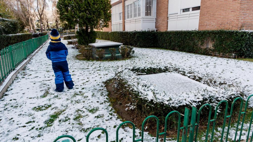 Un niño juega con la nieve en un jardín de Madrid.