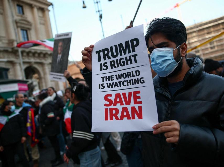 Un hombre muestra un cartel que pide al presidente estadounidense Donald Trump que intervenga en Irán durante una protesta este miércoles en Roma.