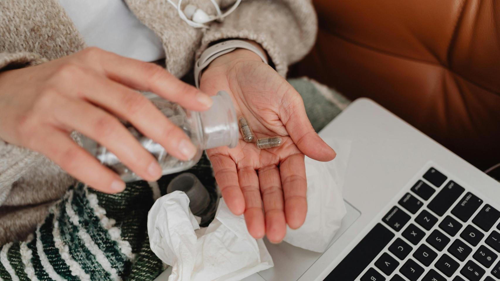 Una persona se dispone a tomarse una pastilla.