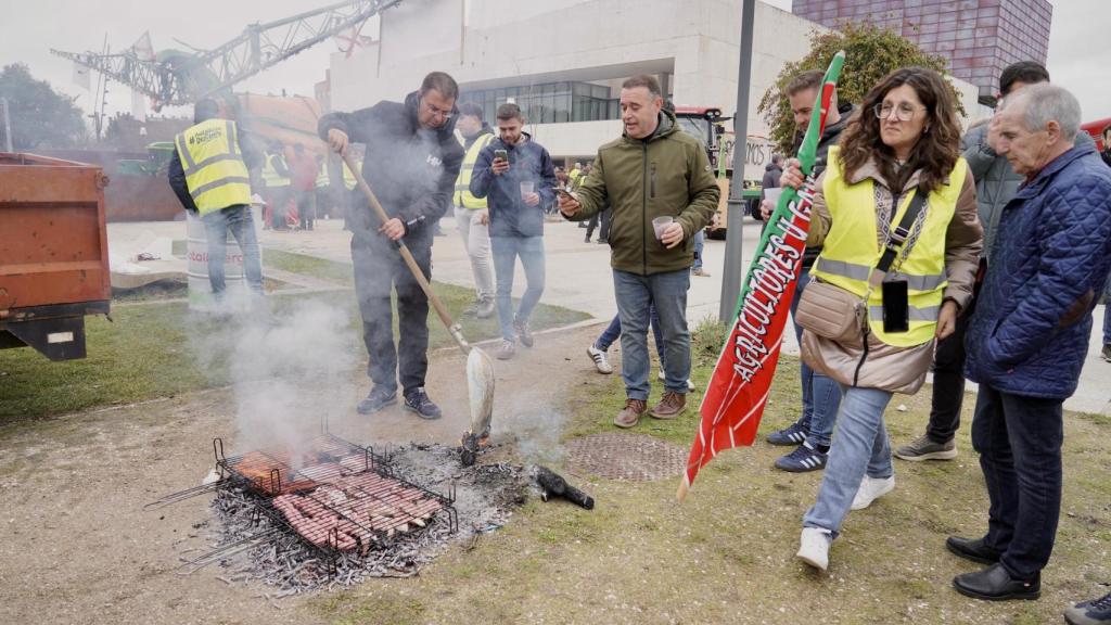 Agricultores y ganaderos preparan una barbacoa junto a las Cortes durante las protestas